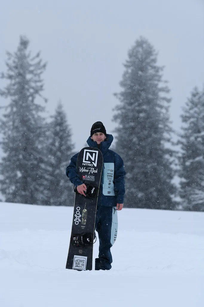 Portrait von Finn mit seinem Snowboard.